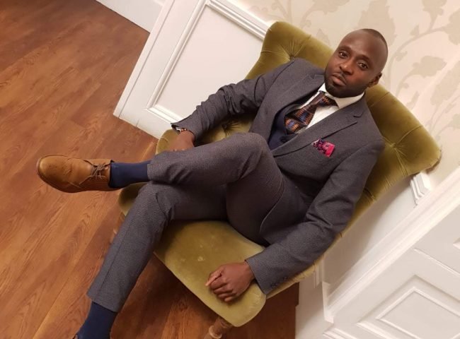 Adrian Daniels wearing a suit at a wedding